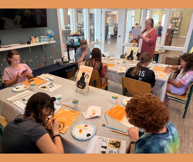 Stephanie Sechman guides students painting orange-and-black Halloween scenes at Annville Free Library.